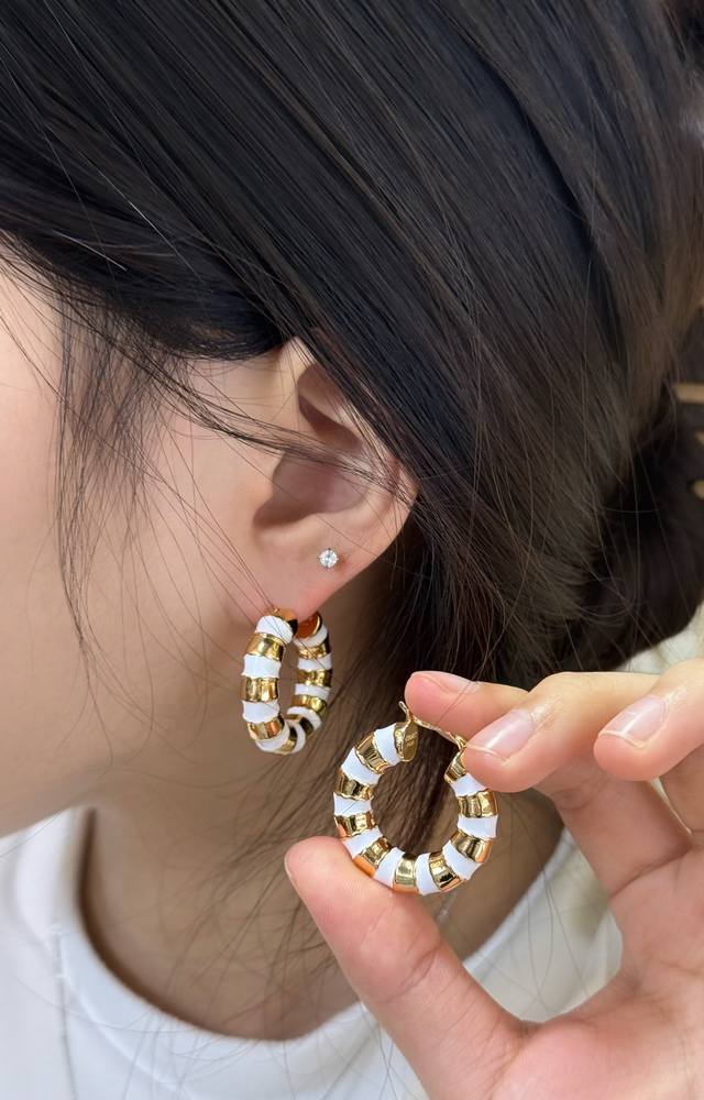 CéLine 白金拼色耳环 CéLine白金拼色耳环，金属与白色珐琅拼接，简约又有现代感。圆形环状设计，尺寸适中，日常佩戴超百搭，轻松提升穿搭精致度。金属部分抛