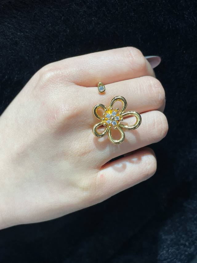 v金材质 Vca花蕊带钻开口戒指码数 5678码 采用镂空五瓣花朵造型，线条流畅又富有立体感，花瓣是灵动的线条，不会显得呆板。花心镶嵌了一圈闪亮的锆石，像露珠点