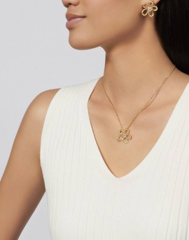 v金材质 Vca花蕊带钻项链采用镂空五瓣花朵造型，线条流畅又富有立体感，花瓣是灵动的线条，不会显得呆板。花心镶嵌了一圈闪亮的锆石，像露珠点缀在花蕊上，让整朵“花