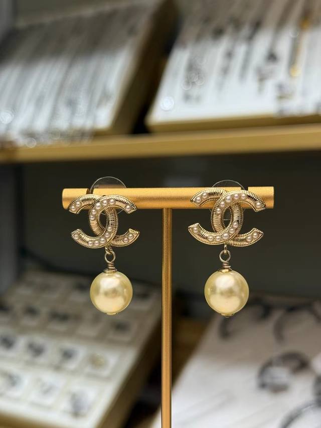 香奈儿珍珠双C耳环 香奈儿经典双C珍珠耳环，浅金色金属搭配小珍珠点缀，复古又高级。下方大颗仿珍珠吊坠，灵动优雅，日常或正式场合都能轻松驾驭。双C标志超有辨识度，
