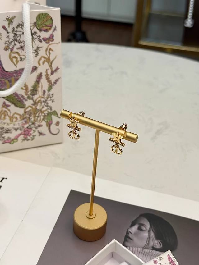 Dior星星吊坠耳环 Dior星星吊坠耳环，金属镀金材质，搭配精致星和 Cd 标志，优雅又有辨识度。星星镶嵌细钻，闪耀吸睛，链条连接 Cd 吊坠，品牌感满满长度