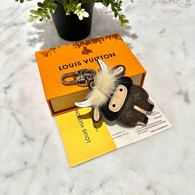 配图片原版包装 Louis Vuitton 官网M80218 中国新年包饰与钥匙扣。 本款中国新年包饰与钥匙扣配有牛形挂件，由小牛皮与标志性Monogram帆布