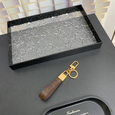 Louis Vuitton路易威登 挂锁钥匙圈和包饰 这款全新Lv挂锁带款式是一款精致的 配饰，可用作钥匙圈和包饰。该品牌的标 志性挂锁上刻有Lv缩写，而登山扣