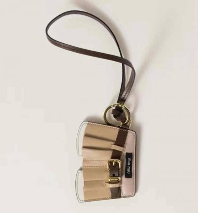 新品 -Miumiu缪缪皮革裙子挂绳挂件 -Miu Miu 衣柜中的独特元素变身为珍贵的手袋配饰 实现俏皮而个性的组合 这款皮革手袋的设计灵感来自 Miu Mi