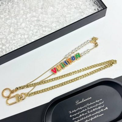vuitton 腰带链及包饰短款 Vuitton 腰带链以双链设计宣示潮流个性：一条融汇珠饰，并以金属串珠拼写 Vuitton 标识，另一条借链环释放经典韵味。