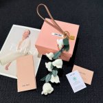新品 -Miumiu缪缪皮革铃兰花包挂挂绳挂件 -Miu Miu 衣柜中的独特元素变身为手袋的珍贵配饰 实现俏皮而个性的组合 这款皮革手袋的灵感来自经典府绸衬衫