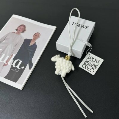 P200-新品 罗意威Loewe 毛毡和牛皮革绵羊挂饰 挂件 颜色：白色 毛毡制成的绵羊挂饰，连接有牛皮革环带和 Anagram骰子 采用进口小牛皮 可挂于包包