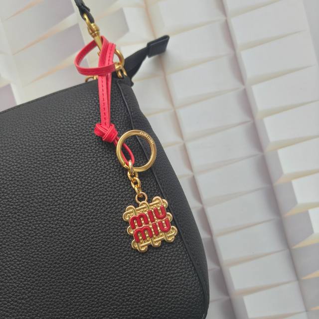 p70Miumiu款金属徽标和牛皮革挂饰采用象征着统一和联结的传统绳结设计。可用做钥匙扣或搭配手袋和配饰，打造别具 Miu Miu '造型。 带环圈 配带子 醒