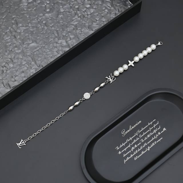 Pearls Fusion 手链 M1556A Pearls Fusion 手链以金属串珠和玻璃珠饰营造不对称设计，将 Monogram 花卉铭纹装饰和 Lv