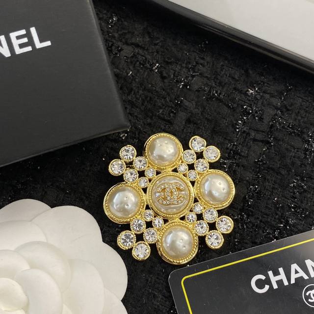 香奈儿胸针热销款爆上新 Chanel高级手工坊胸针，做工精细，一致黄铜 加入了树脂珠、水钻，中间钻双C小Logo镶嵌，玛丽复古风！ 高级又贵气，搭配单品No.1