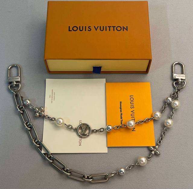 Lv Figaro 腰带链以莹泽黄铜锻造双链设计，再令品牌经典标识巧妙嵌入链环之间。Lv字母装饰于一端优雅垂坠，弹簧扣实现轻松固定，为裤装或手袋注入潮流锋芒。