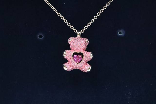 Swarovski 心动粉钻泰迪熊 项链耳环套装 让这款多变的耳环为您打造专属的造型。其灵感源自经典的童年形象，同时采用时尚的不对称设计。一只耳环为 3D 泰迪