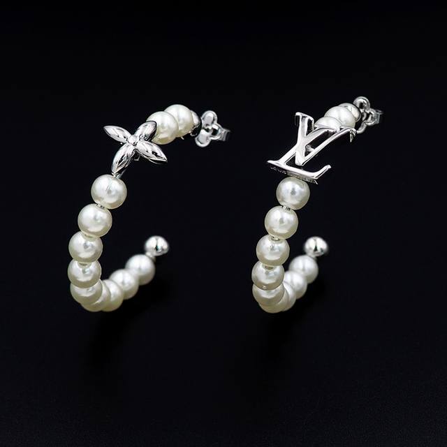 驴家My Lv Pearl 耳环以不对称设计创意演绎夏日风范。耀目金属雕琢 Lv字母和 Monogram 花卉，莹润白色树脂珠饰致意海洋的深邃无垠，可为昼夜造型