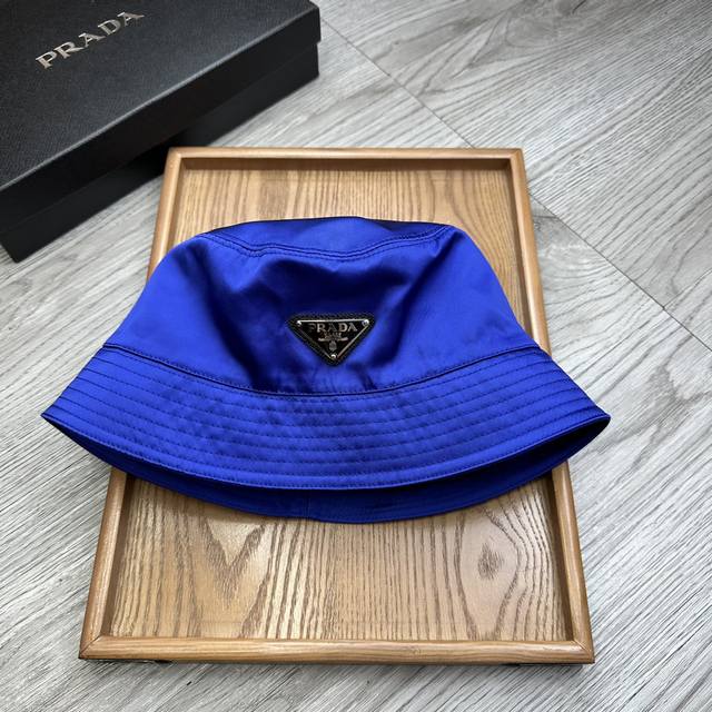 特价 。Prada家。高端品质！ 克莱因蓝 平顶经典三角标铁标渔夫！ 高版配防尘袋 高端舒适！高端材质！！今年帽子第一流行趋势绝对是渔夫帽！今年的渔夫帽满目玲琅