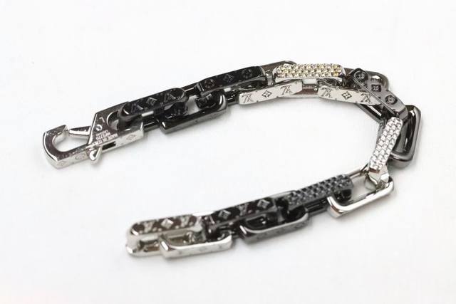 新品 Lv 镶钻黑白竹节 淬火情侣手链 Monogram Chain 手链为粗犷工业风格链环镂刻品牌经典图案，挥洒舒朗刚毅的美学风范。璀璨人造水晶辉映色彩和质感