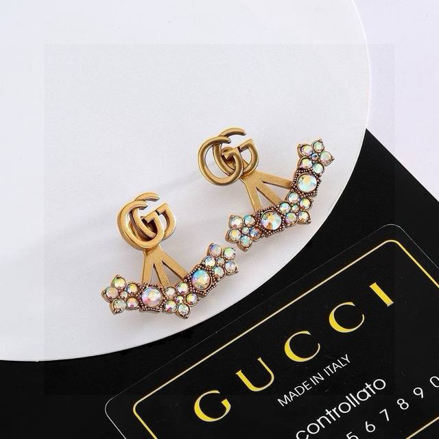 gucci双G古驰耳钉 作为品牌的标志性元素，运用品牌首字母以别致的方式呈现。金色效果金属标识与白色玻璃珍珠边框相得益彰，令整款设计更显精致典雅的气息。融合了品