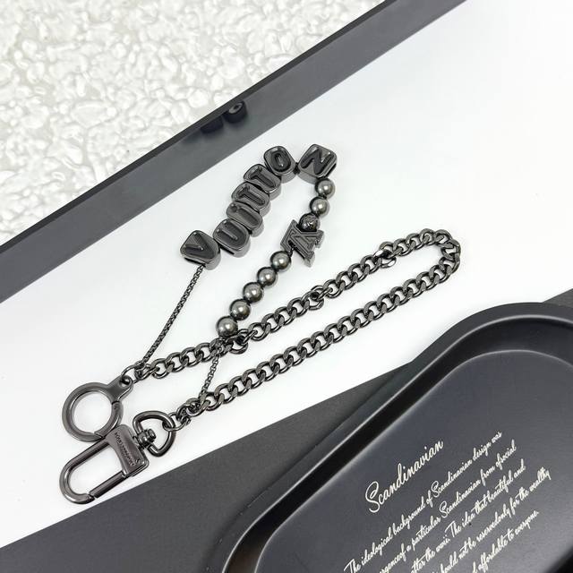 vuitton 腰带链及包饰短款 .Vuitton 腰带链以双链设计宣示潮流个性：一条融汇珠饰，并以金属串珠拼写 Vuitton 标识，另一条借链环释放经典韵味