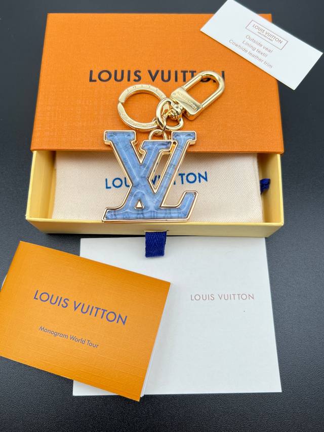 Lv Gloss 钥匙扣将有机玻璃 Lv 字母镶嵌于耀目金属之中 其上点缀 Nanogram 图案 以明丽笔触灵动演绎夏日风情 可轻松点亮各式手袋或钥匙 金属