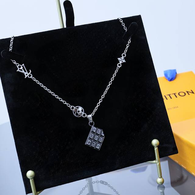 Lv Chocolate Bar 坠饰 Mo2567 Lvchocolate Bar 坠饰为不同方格镂刻 Lv 字母和 Monogram 花卉，以边角的不规则缺