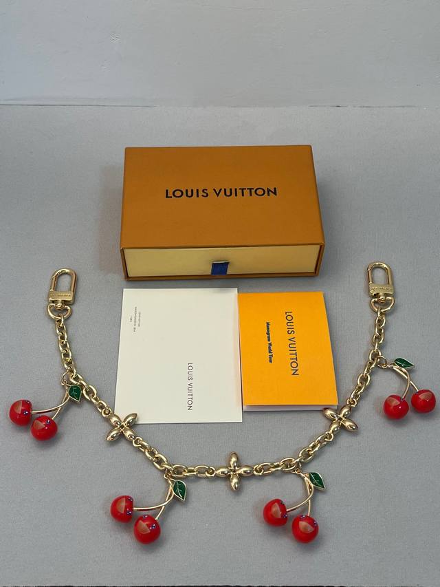 Lv X Tm Cerise 链条包饰 Lv X Tm Lv Cerise链条包饰出自路易威登X村上隆复刻系列，为双链条设计融入Lv字母和明媚樱桃装饰，道出日本