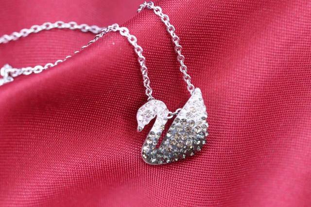 Swarovski 小黑渐变天鹅项链 这款优雅迷人的镀白金色链坠，以现代手法演绎品牌标志 天鹅的高贵魅力。通过独有的Pointiage低温陶瓷镶嵌技术，链坠精心