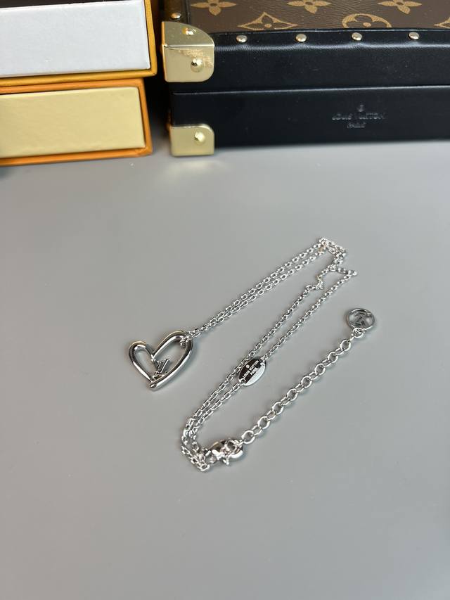 Lv 爱心 项链，Fall In Love Heart 项链以温婉笔触勾勒心形吊坠，悬挂于纤细颈链，可灵巧贴合锁骨线条。中央Lv字母和Lv Circle 标识装