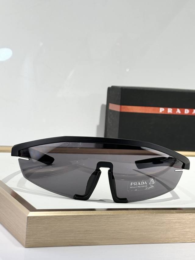 Prad* Model：Sps03Z 太阳镜采用超现代的全包围设计 前部由一个单镜片组成 具有干净、功能性的切割 作为创新的横向通风系统。 直边的镜架装饰有标志