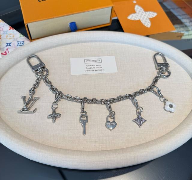 Lv钥匙扣 官网新款 包包链条挂件 多功能链条 包饰&包包肩带延长链 本款链条包饰出自路易威登X村上隆复刻系列，为耀目链条交错排布 Monogram 花卉和Ch