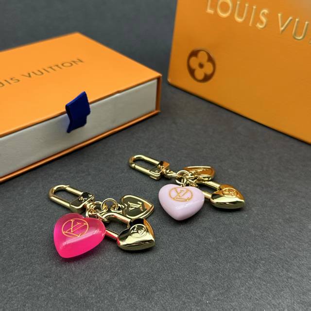 Micro Charms Heart包饰结合莹亮金属和缤纷锦纶，为心形装饰点缀Lv字母和 Lv Circle标识，在浪漫氛围中展露品牌格调。优雅设计传递柔情蜜意