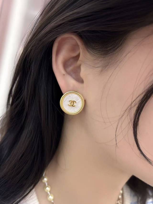 香奈儿Chanel 大圆饼耳环设计精巧，如25A镂空爱心款，淡金色菱格边框搭配满钻双心，精致复古。还有金色熔岩爱心款，镶嵌双C标志，尽显优雅奢华，是时尚搭配的点