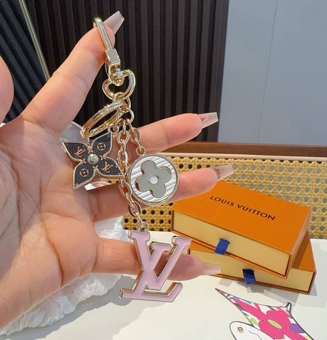 Lv 钥匙扣包挂件 Spring Street Chain 包饰将 Monogram 花卉和 Lv 字母等经典元素化为袖珍挂饰，在淡雅色彩和 Monogram