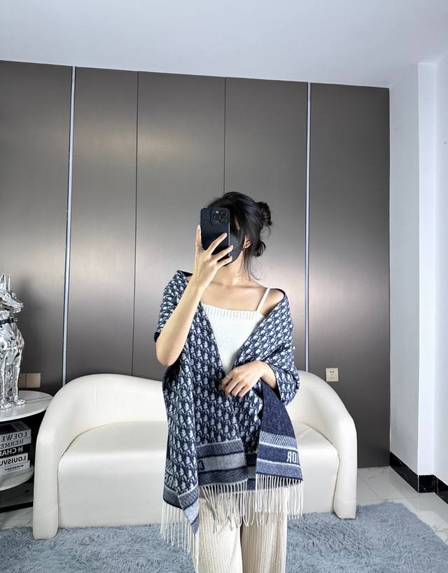 年Dior最新款 这款 Oblique 印花围巾重新诠释 Dior 经典标识，彰显现代精神。采用海军蓝色山羊绒精心制作，双面设计，一面采用纯色，另一面饰以 Di