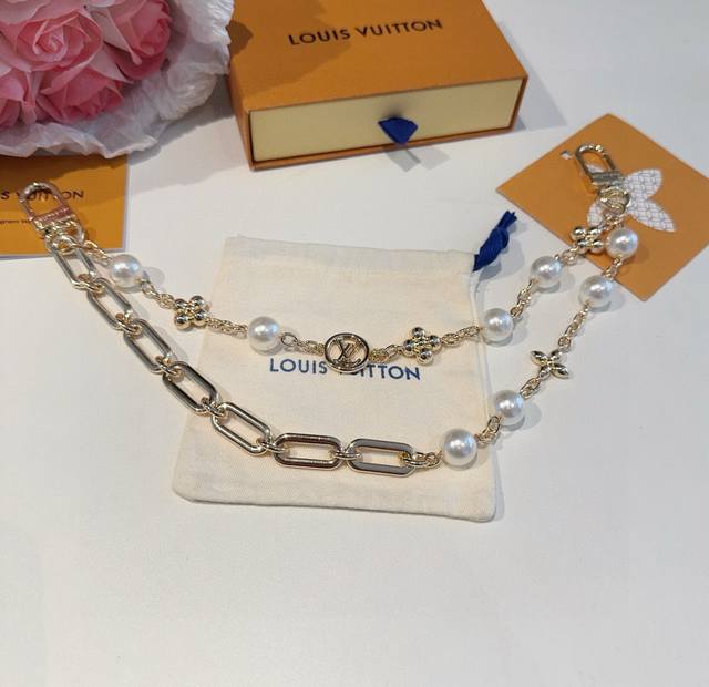 Lv钥匙扣 包包挂链 Figaro 腰带链以莹泽黄铜锻造双链设计，再令品牌经典标识巧妙嵌入链环之间。Lv字母装饰于一端优雅垂坠，弹簧扣实现轻松固定，为裤装或手袋