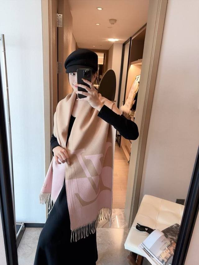 Lv 2.0 围巾为柔软山羊绒标注 Monogram 花卉和 Lv 字母，其间点缀品牌名称的单一字母，以摩登风姿焕新经典。加长设计适宜环绕颈部，亦可用作巴拉克拉