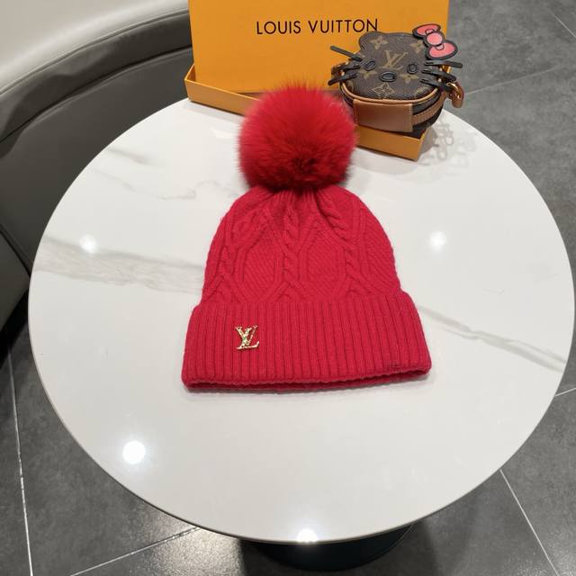 毛线帽经典麻花编织设计，帽身配有金色Lv标志。配狐狸毛球帽子采用优质羊毛+兔毛针织面料，保暖舒适，帽顶配有同色系毛球装饰，时尚大方。 帽子细节： - 经典麻花编