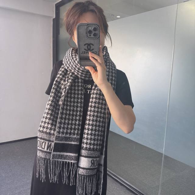 Dior Montaigne系列 这款围巾向经典的黑色和白色千鸟格纹图案致敬。采用高级面料精心制作，双面设计，饰以流苏饰边，点缀以对比鲜明的 Christian
