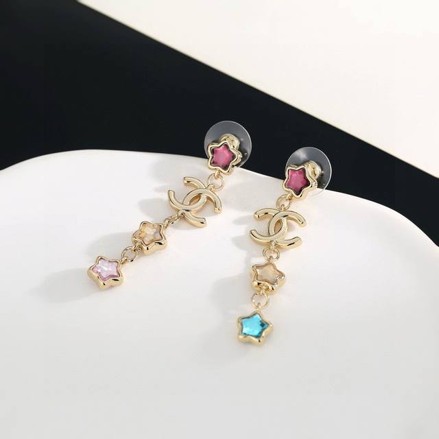 香奈儿新款星星彩色系列长款耳钉，更修饰脸型。以金色金属边环绕给人一种神秘、成熟、复古的感觉。双C金属标志树脂撞色经典百搭！耳钉