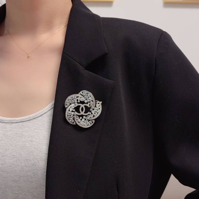 Chanel小香 最新款高版本银色满钻香奈儿山茶花胸针，是最懂女人的饰物。那些倾注了全部心血去做自己的女人，往往更珍惜胸针的意义。香奈儿女士把胸针别在帽子上，并