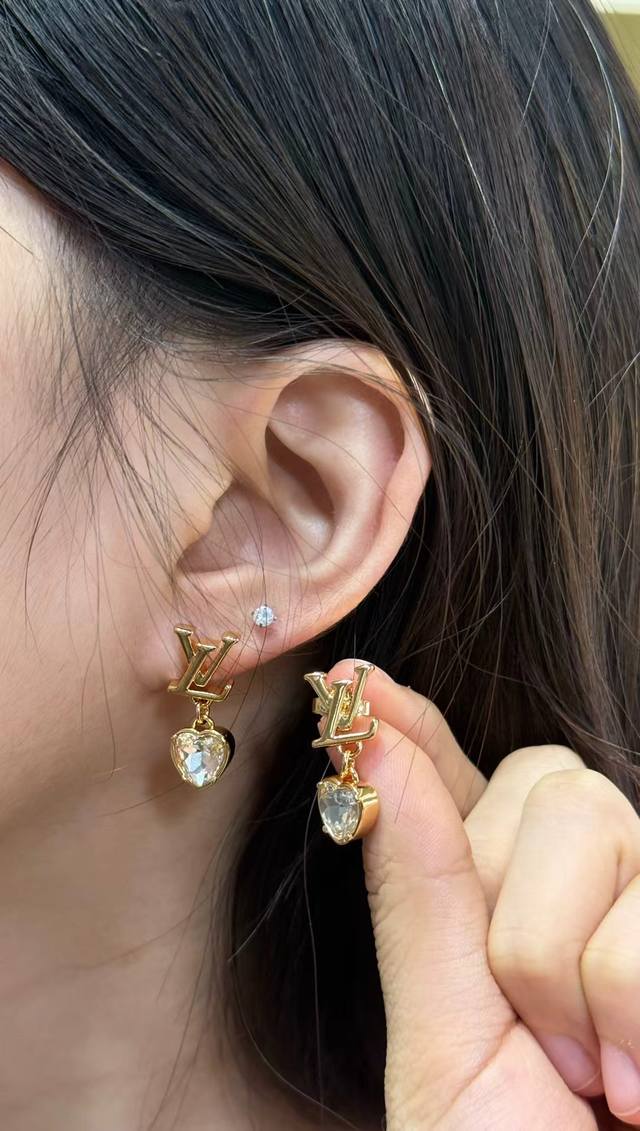 Lv Monogram爱心耳环 Lv Monogram系列爱心耳环，金色金属搭配透 明水晶，精致又奢华吊坠式设计，经典Lv标