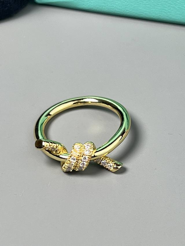 蒂芙尼Tiffany Knot 系列标志性设计中相互缠绕的未端，是情感联系的有力象征。Tiffany 这款戒指采用 18K 黄金铺镶钻石设计，经手工抛光打磨，散