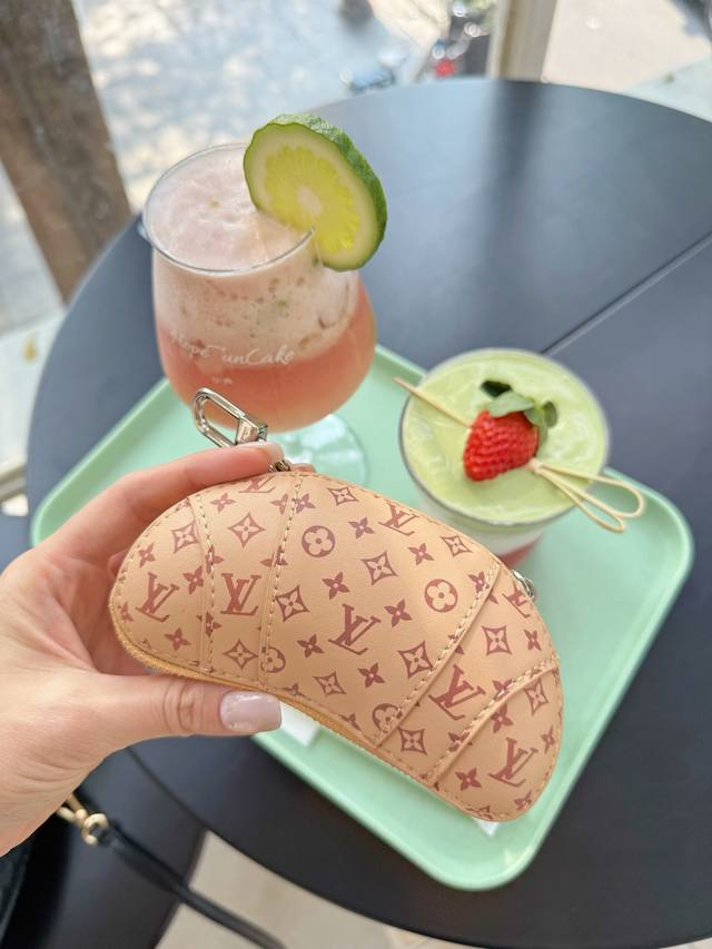 新品迷你牛角包挂件挂饰 Louis Vuitton 路易威登牛角包耳机包挂饰挂件 户外休闲穿搭的包包搭配一个精美的挂饰，时尚感满满且十分亮眼。这款牛角包形状挂饰