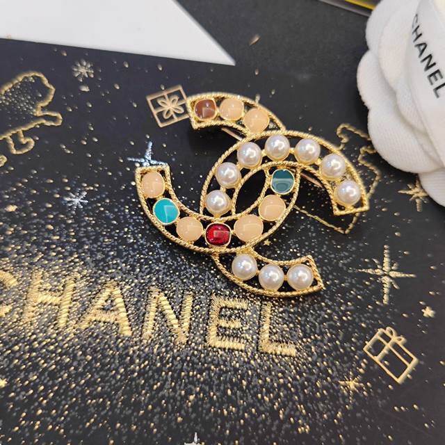 Chanel小香 专柜新款彩宝珍珠字母搭配香奈儿胸针，是最懂女人的饰物。那些倾注了全部心血去做自己的女人，往往更珍惜胸针的意义。香奈儿女士把胸针别在帽子上，并告