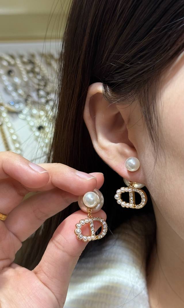 Dior珍珠吊坠耳环 Dior这款珍珠吊坠耳环，金属铜镀金材质，搭配仿珍珠和水钻，经典 D 字母标志超有辨识度